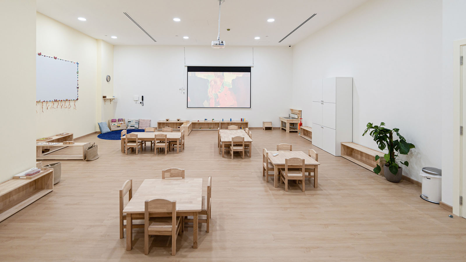 Modern spacious preschool classroom interior with wooden furniture